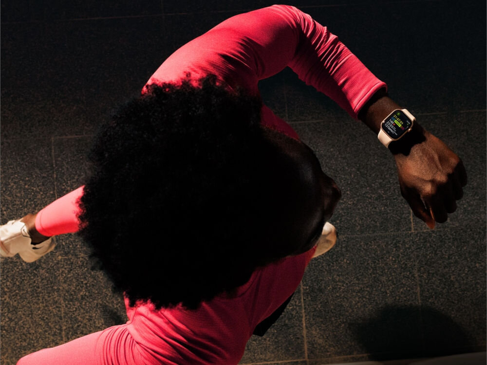 Apple Watch 11 GPS 42mm koperta z aluminium (różowe złoto) + pasek sportowy rozmiar S/M (łagodny róż) mężczyzna biegnący po ciemnym chodniku z założonym zegarkiem analiza obciążenia treningowego treningi personalizacja dane muzyka