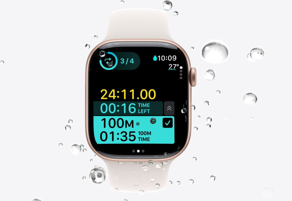 Apple Watch 11 GPS 42mm koperta z aluminium (gwiezdna szarość) + pasek sportowy rozmiar S/M (czarny) prezentacja zegarka od przodu na jasnym tle na nim i obok krople wody wodoodporność WR 50M odporność na pył IP6X