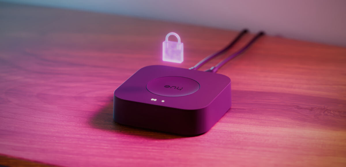 Bramka PHILIPS HUE Bridge Pro Eu, system, Inteligentne, oświetlenia, bezpieczeństwo, na drewninanym blacie hue brudge z wizualizacją kłódki nad nim