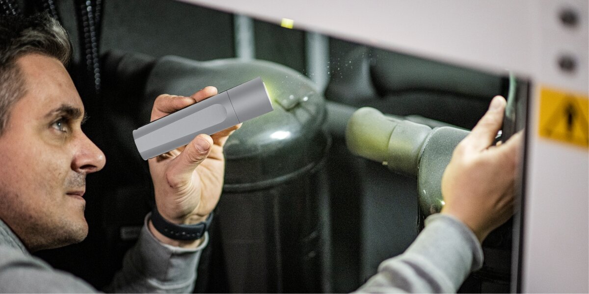 Latarka Hama FL60 Srebrny, wytrzymałość, trwałość, energooszczędność, wszechstronność, Mężczyzna używa latarki podczas naprawy urządzenia przemysłowego, silne światło LED.