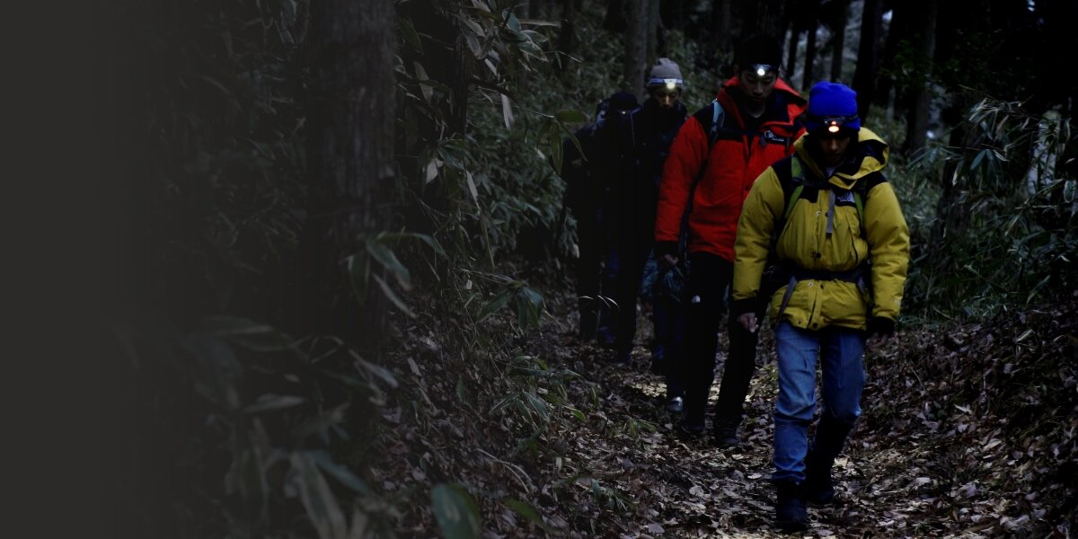 Latarka czołowa HAMA HL110, bieganie, warsztat, biwak, wspinaczka, Grupa turystów idzie nocą w lesie w czołówkach