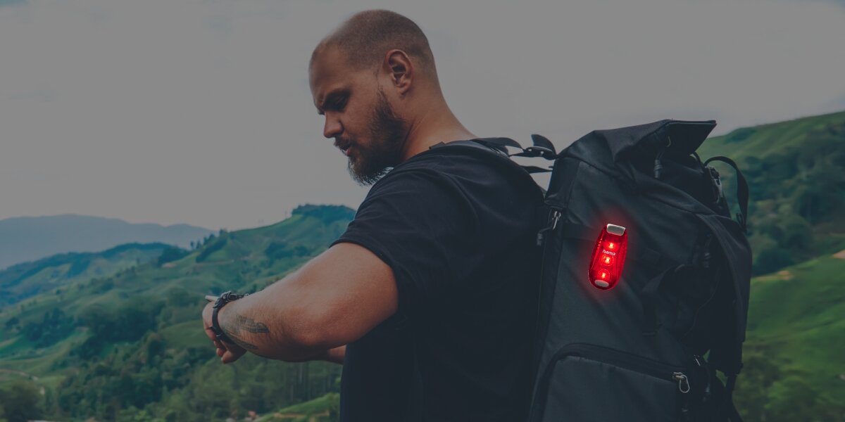 Lampka ostrzegawcza HAMA SL-DUO  Czerwono-szary (2 szt.), lampka, LED, bezpieczeństwo, widoczność, mężczyzna przemierza górzysty teren z lampka zamontowaną do plecaka