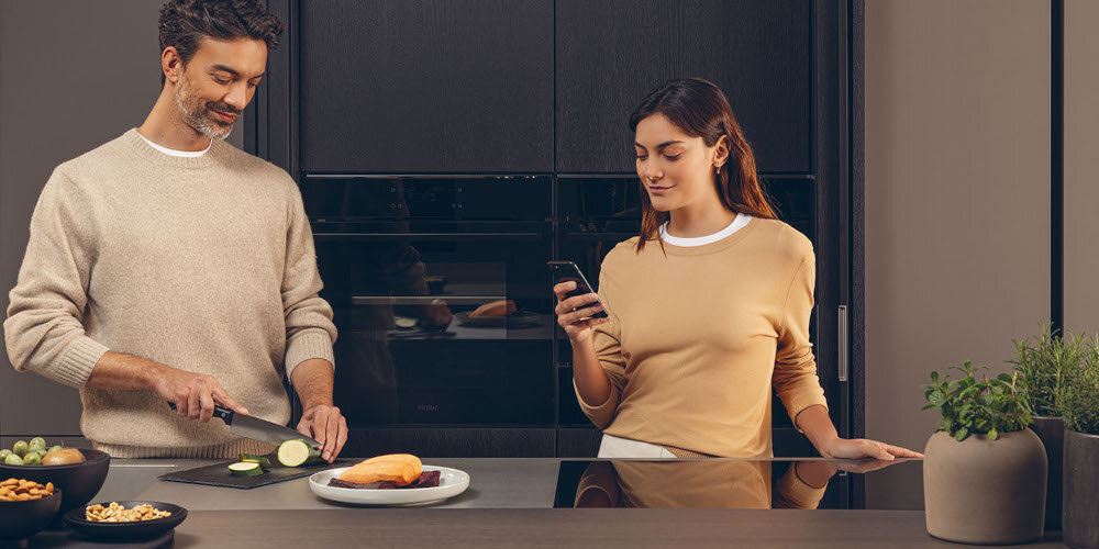 PŁYTA HAIER HAISJ64MC zdjęcie lifestyle kuchnia gotowanie mężczyzna kobieta piekarnik zabudowa przyrządzanie posiłku deska nóż funcja timer czas regulacja godzina planowanie
