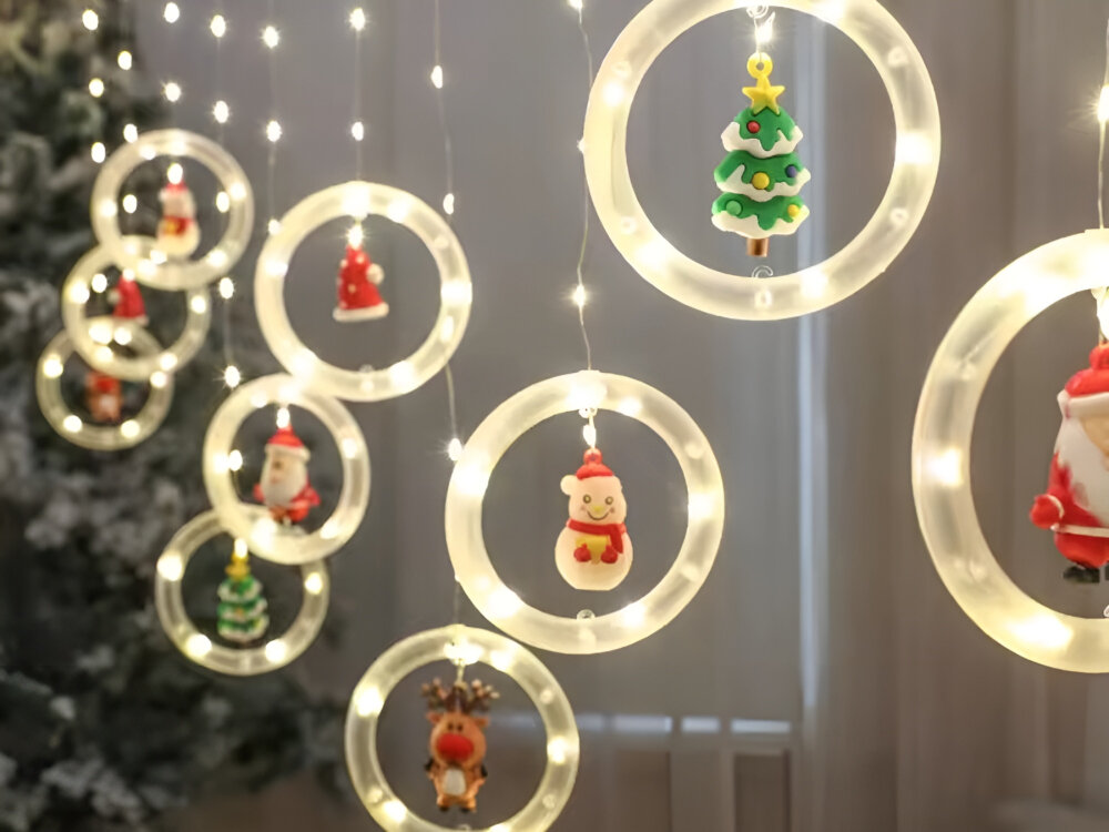 LAMPKI ŚWIĄTECZNE BELINE ZESTAW 10 SZTUK OKRĄGŁY LED, Dziesięć, kółka, przestrzenna, dekoracja, w tle choinka w pokoju gościnnym, na pierwszym planie kurtyna z lampek świątecznych beline