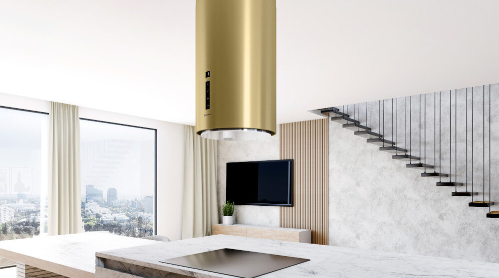 Okap GLOBALO Heweno Isola 39.2 Złoty mat Zdjęcie przedstawia tę samą kuchnię z innej perspektywy, ukazując efektowny, złoty okap kuchenny zawieszony nad płytą indukcyjną na wyspie kuchennej. W tle widać duże okna z panoramicznym widokiem na miasto salon połączony z kuchnią, co podkreśla przestronność i styl wnętrza wyciąg pochłaniacz wentylacja oczyszczanie powietrza obieg zamknięty elegancki design