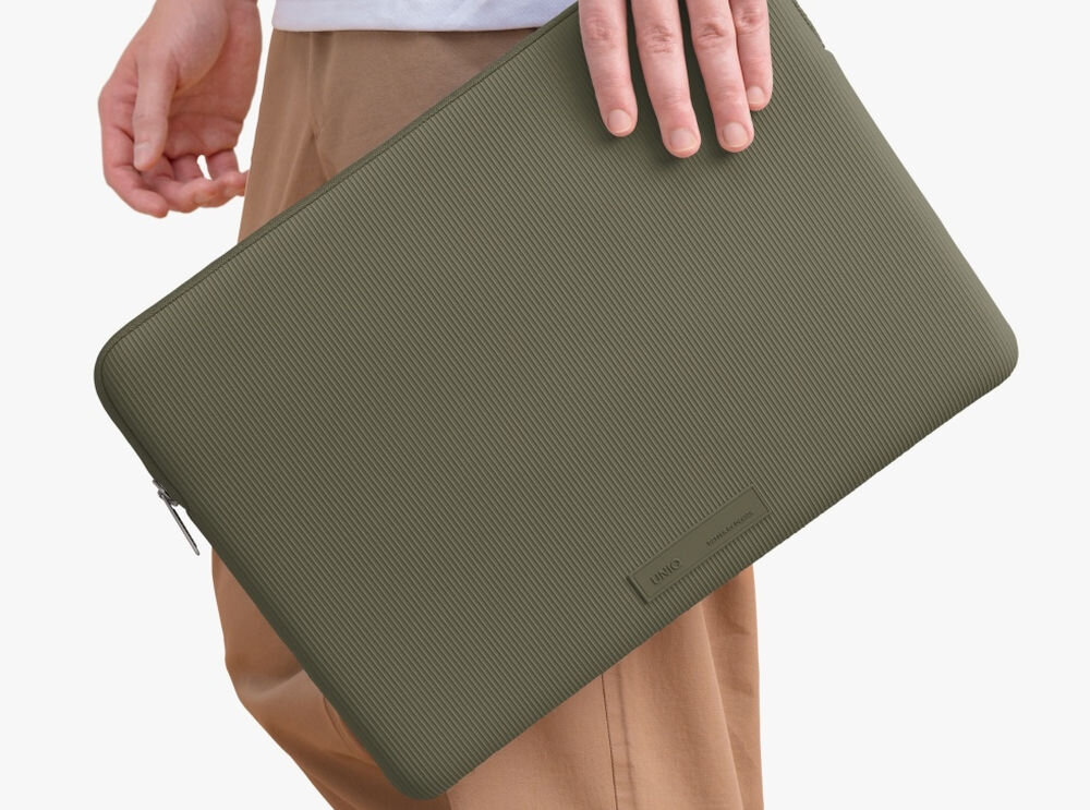 Torba na laptopa UNIQ Cyprus Ridge Edition 14 cali Zielony, elegancja, ochrona, opakowanie, bezpieczeństwo, osoba stoi bokiem trzymając w dłoni torbę na laptopa