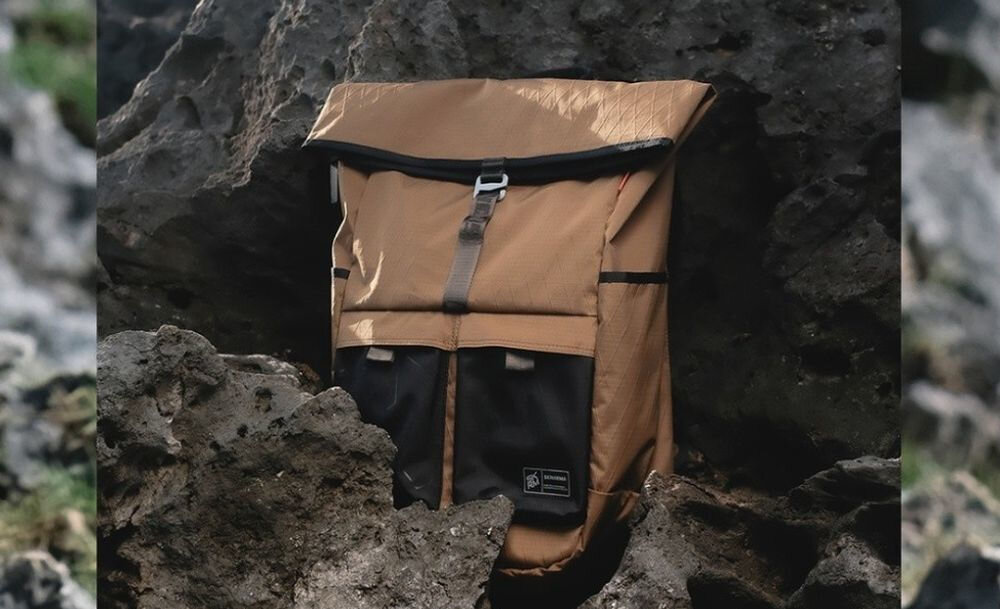 Plecak SKINARMA Jager Brązowy prezentacja plecaka pomiędzy skałami wygodne szelki i trolley sleeve wygoda mocowanie do walizki podróż