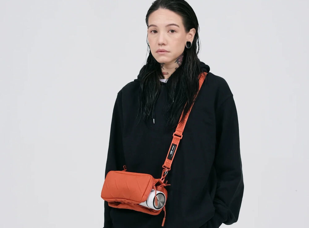 Torebka na telefon SKINARMA Juno Czarny dziewczyna z założoną torebką na szarym tle połączenie stylu i technologii singapurska marka