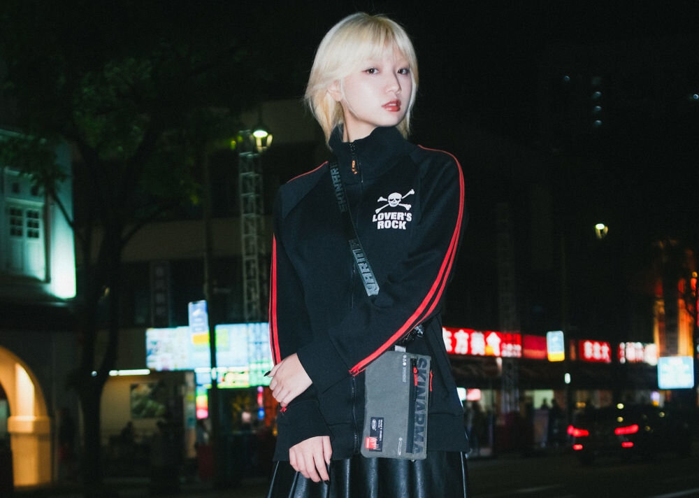 Torebka na telefon SKINARMA Fardel Oliwkowy prezentacja torebki na dziewczynie stojącej przy ulicy