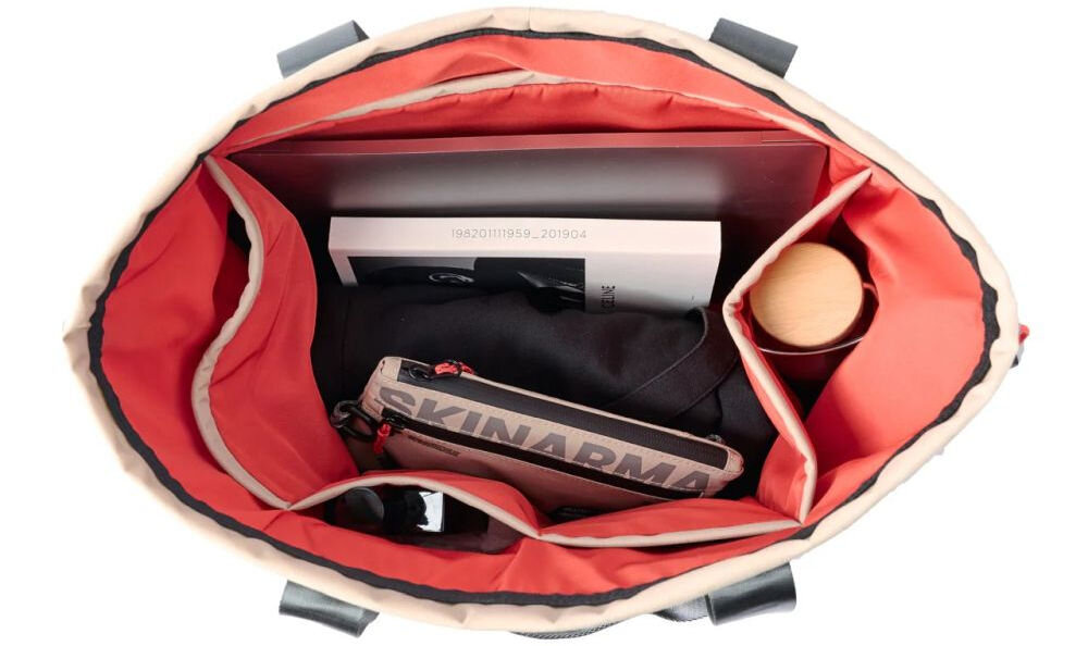 Torba SKINARMA Fardel Kość słoniowa prezentacja torby na białym tle pokazanie wnętrza z kieszeniami uchwyty antypoślizgowe wewnętrzne kieszenie utrzymanie porządku system ściągania na sznurek komfort noszenia