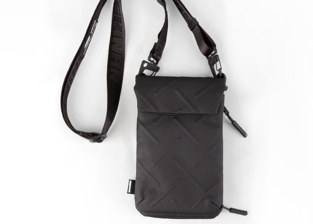 Torebka na telefon SKINARMA Juno Czarny prezentacja leżącej torebki na jasnym tle połączenie stylu i technologii singapurska marka