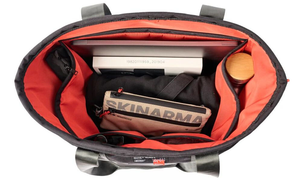 Torba SKINARMA Fardel Czarny prezentacja torby na białym tle pokazanie wnętrza z kieszeniami uchwyty antypoślizgowe wewnętrzne kieszenie utrzymanie porządku system ściągania na sznurek komfort noszenia