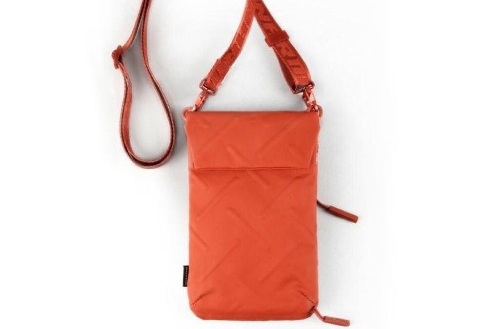 Torebka na telefon SKINARMA Juno Pomarańczowy prezentacja leżącej torebki na jasnym tle połączenie stylu i technologii singapurska marka