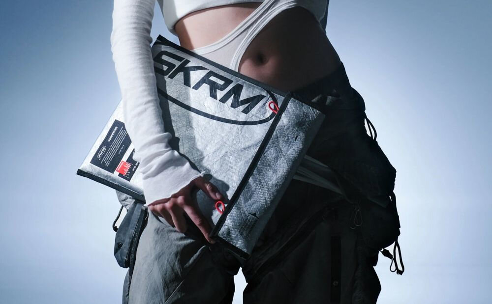 Torba na laptopa SKINARMA Comet 14 cali Czarny prezentacja torby trzymanej w ręce na jasnym tle z poświatą światła marka łącząca styl i technologię charakter wyrażanie osobowości użytkownika funkcjonalność estetyka