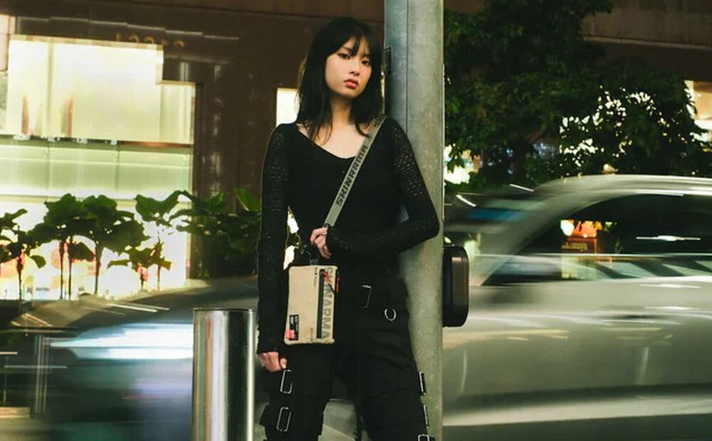 Torebka na telefon SKINARMA Fardel Kość słoniowa prezentacja torebki na dziewczynie stojącej przy ulicy