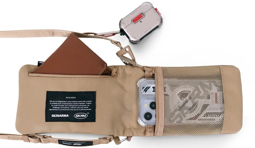 Torebka na telefon SKINARMA Juno Khaki prezentacja otwartej torebki z wystającym telefonem i portfelem na białym tle torba crossbody z kieszeniami i paskiem SCOUT+ magnetyczne zamknięcie komfort noszenia szybki dostęp do najważniejszych rzeczy