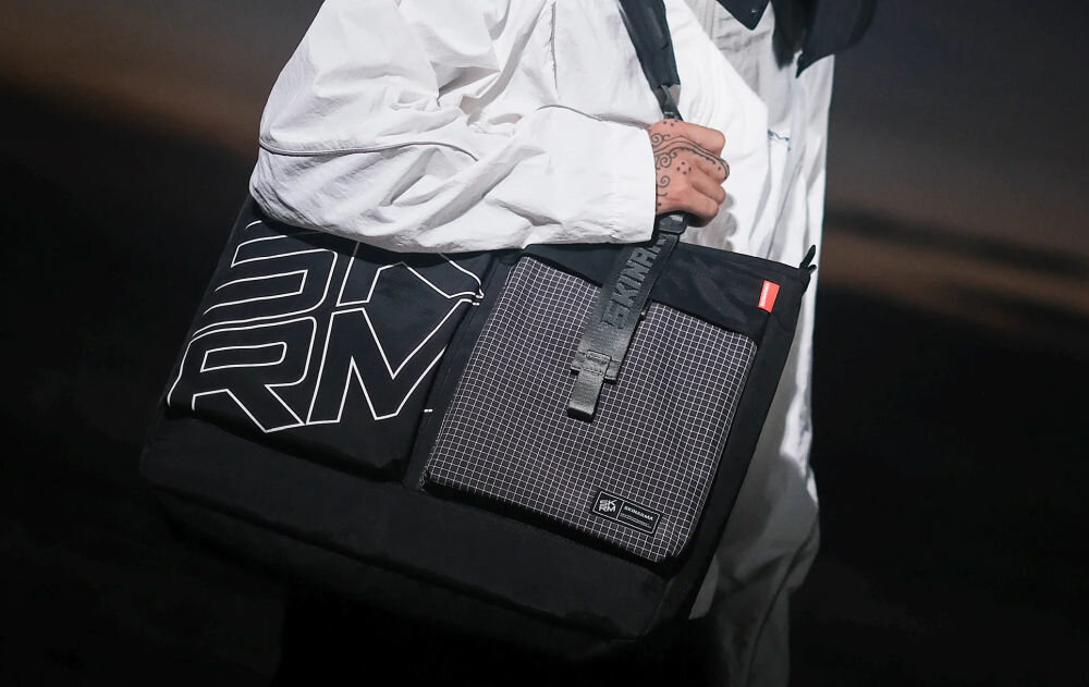 Torba SKINARMA Jager Czarny prezentacja torby założonej na ramię osoby w jasnej kurtce połączenie stylu i technologii funkcjonalność