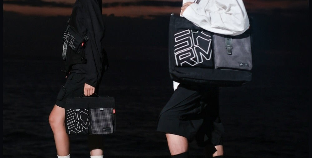 Torba SKINARMA Jager Oliwkowy prezentacja torby założonej na ramię osoby w jasnej i ciemnej kurtce połączenie stylu i technologii funkcjonalność