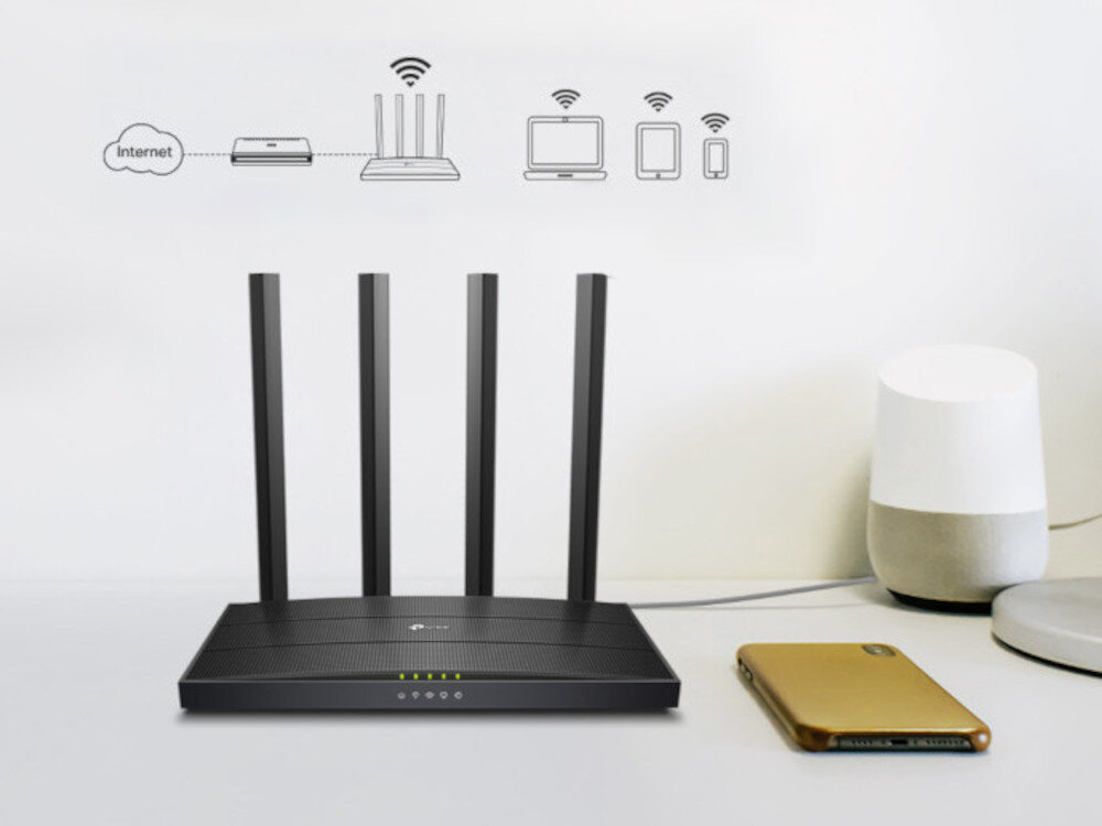 Na biurku znajduje się czarny router z czterema antenami, obok leży złoty smartfon i biały głośnik. Nad routerem widoczne są ikony przedstawiające połączenie z internetem i różne urządzenia, takie jak komputer, tablet i telefon.