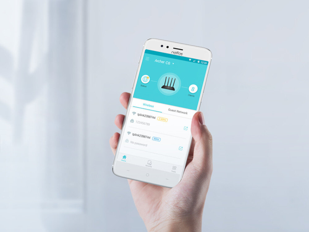 Osoba trzyma smartfon z aplikacją pokazującą ustawienia routera Archer C6. Na ekranie widoczne są nazwy sieci Wi-Fi oraz opcje zarządzania nimi.