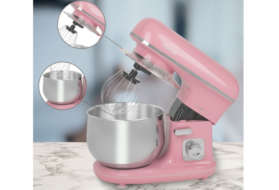 Różowy robot kuchenny z metalową misą i trzepaczką, ustawiony na marmurowym blacie. W tle widoczne są dwa powiększone okrągłe zbliżenia na trzepaczkę i misę.