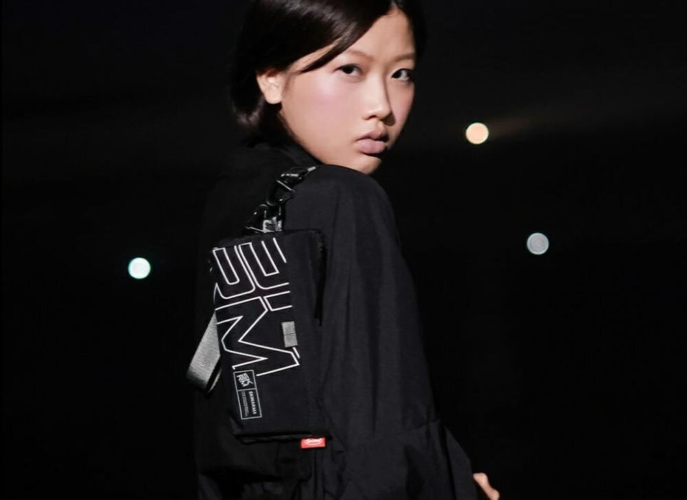 Torebka na telefon SKINARMA Jager Oliwkowy prezentacja torebki założonej na dziewczynie na ciemnym tle połączenie stylu i technologii singapurska marka