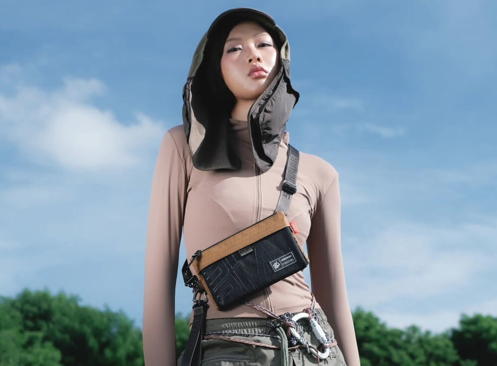 Torebka na telefon SKINARMA Jager Brązowy prezentacja torebki założonej na dziewczynie w tle niebo połączenie stylu i technologii singapurska marka