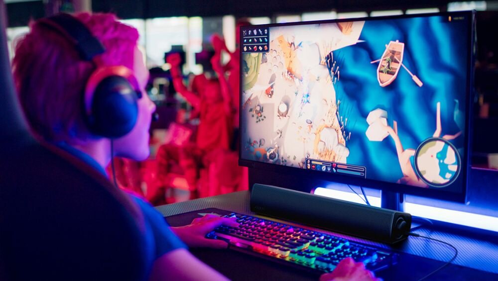 Soundbar komputerowy CREATIVE GS3 2.0 wyjście słuchawkowe z przodu ciche słuchanie bez zakłóceń, osoba grająca na komputerze