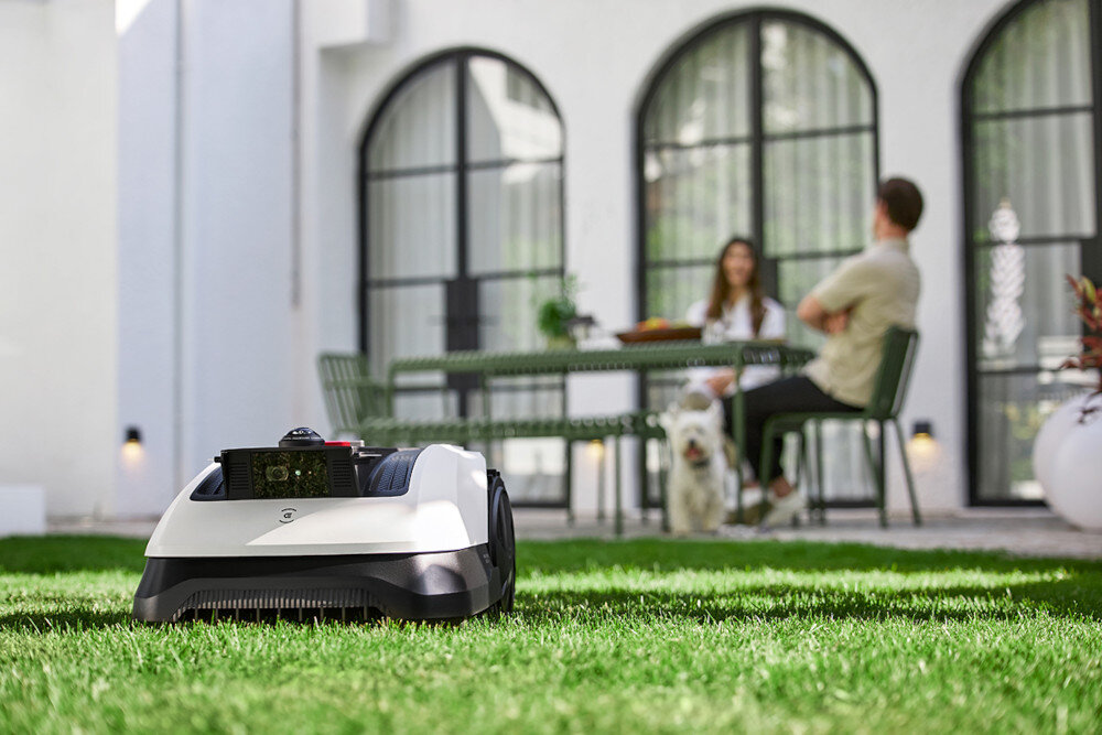 Robot koszący ECOVACS Goat O500 Panorama sterowanie Bluetooth-Wi-Fi robot na trawie w tle osoby na tarasie koszenie bez wysiłku inteligentne koszenie automatyczne koszenie trawy innowacyjne koszenie wygodne rozwiązanie