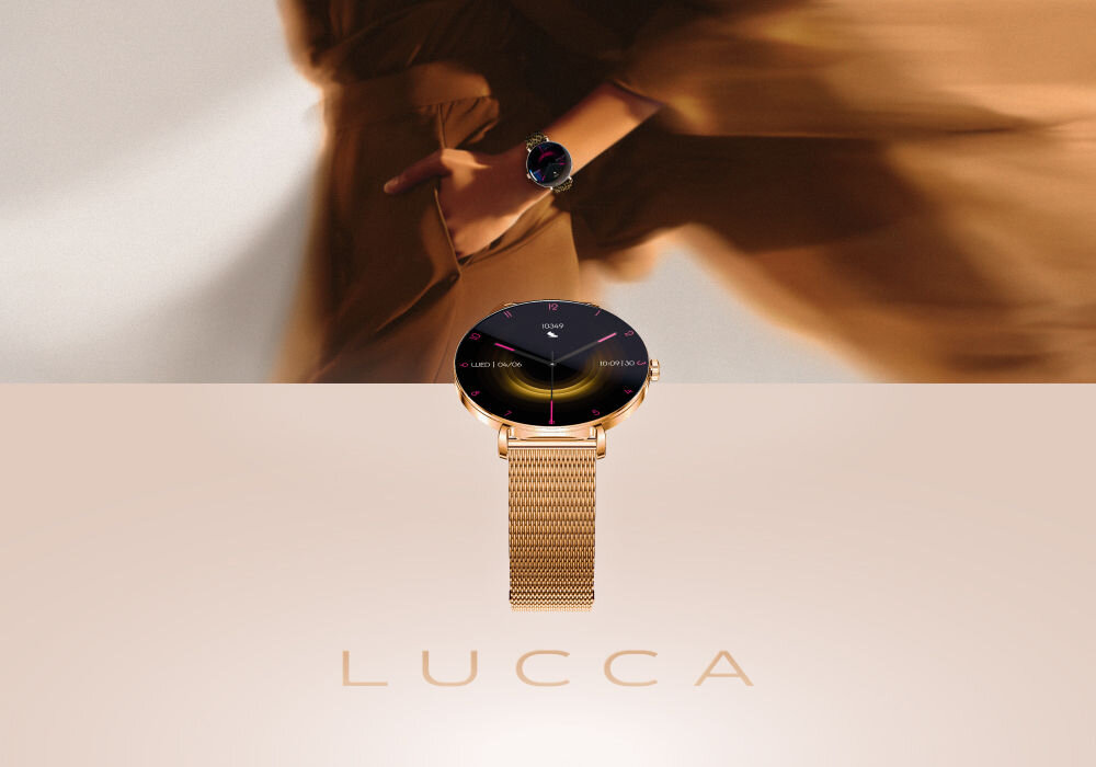 Smartwatch FOREVER SB-370 Lucca Różowe złoto + Pasek w panterkę Smartwatch Lucca w kolorze różowego złota z bransoletą mesh i czarną tarczą, eksponowany na jasnym tle. W tle widać niewyraźną postać kobiety w beżowej odzieży