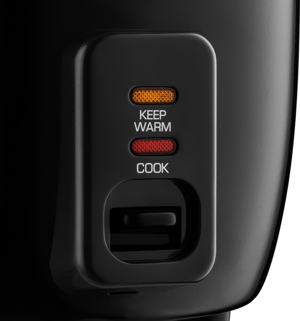 Zbliżenie na panel sterowania ryżowaru z dwoma podświetlanymi przyciskami: \'KEEP WARM\' w kolorze pomarańczowym i \'COOK\' w kolorze czerwonym.