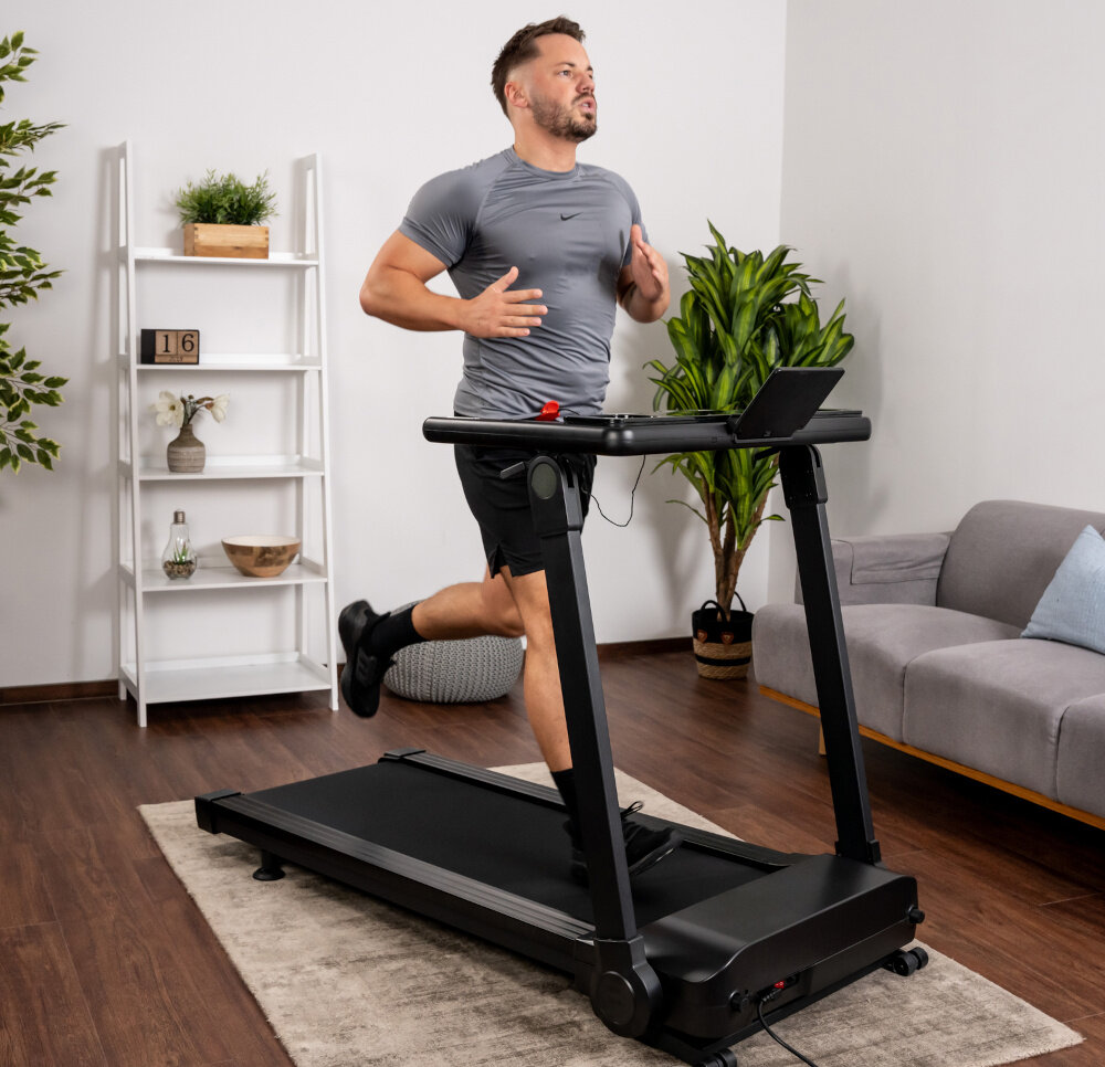 Bieżnia elektryczna KETTLER Track 200 1471W 16 km-h  dom pokój salon osoba idzie na bieżni w tle ściana aktywność w domu zdrowie codzienny trening