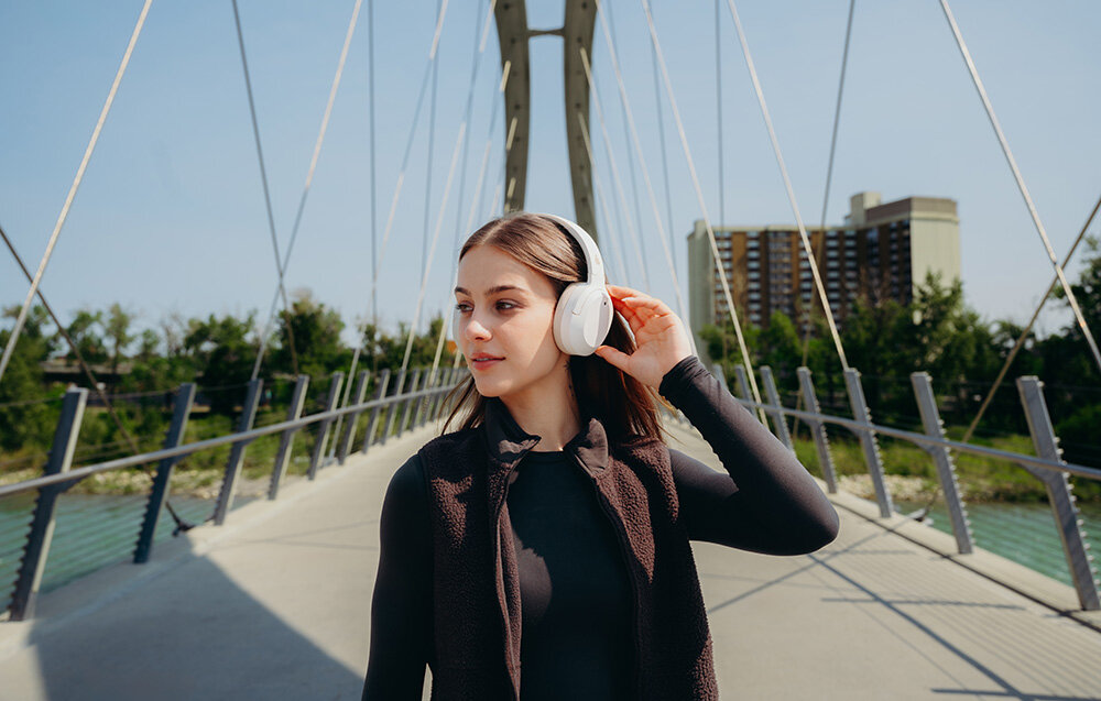 Edifier W820NB Plus V25 słuchawki bezprzewodowe ANC Bluetooth 6.1 LDAC Hi-Res Volume Guard Multipoint, osoba z założonymi słuchawkami nausznymi w plenerze