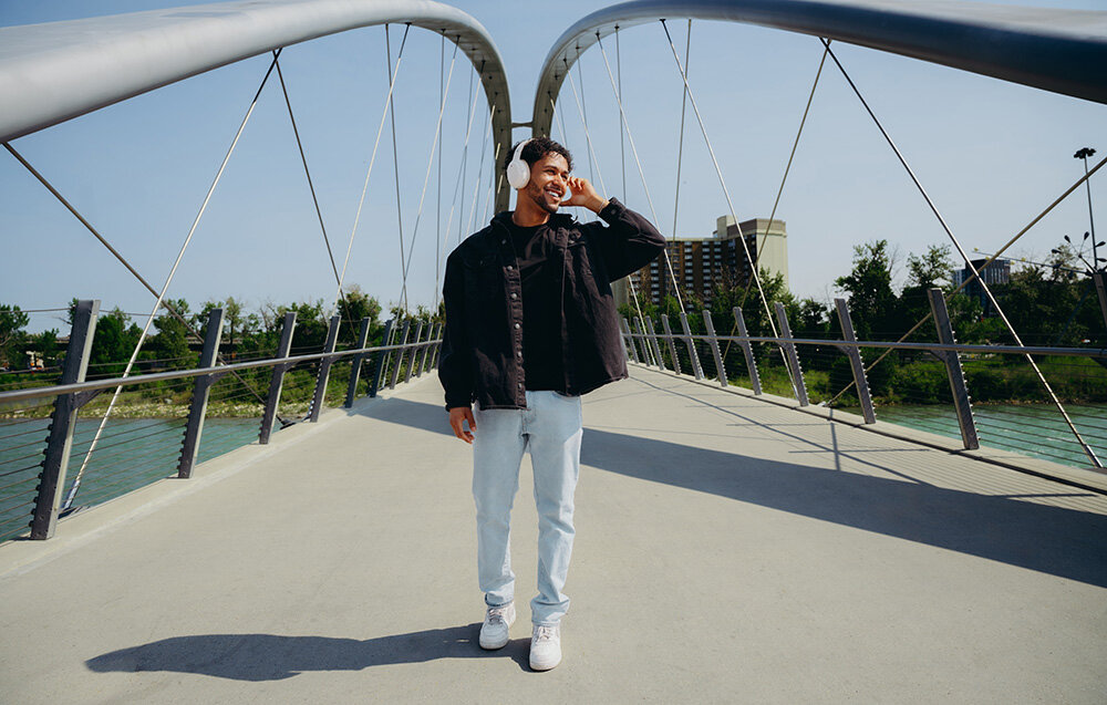 Edifier W820NB Plus V25 mikrofony AI redukcja szumów czysty głos rozmowy telefoniczne wideokonferencje, osoba z założonymi słuchawkami nausznymi w plenerze