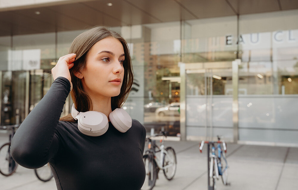 Słuchawki Edifier W820NB Plus V25 bezprzewodowe ANC LDAC Bluetooth 6.1 komfortowe nauszne, osoba z przewieszonymi słuchakami na szyi