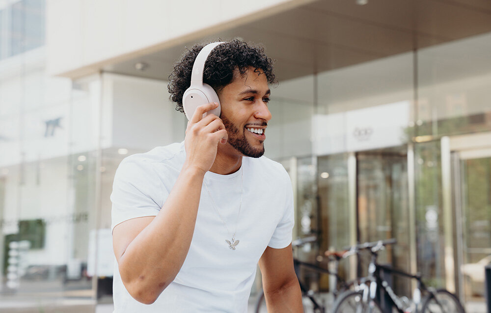 Edifier W820NB Plus V25 słuchawki bezprzewodowe ANC Bluetooth 6.1 LDAC Hi-Res Volume Guard Multipoint, osoba z założonymi słuchawkami nausznymi w plenerze