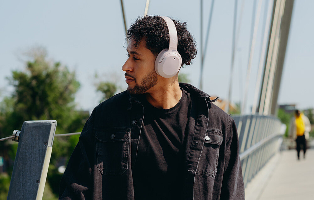 Edifier W820NB Plus V25 komfortowe lekkie słuchawki nauszne regulowany pałąk elegancki design, osoba z założonymi słuchawkami nausznymi w plenerze