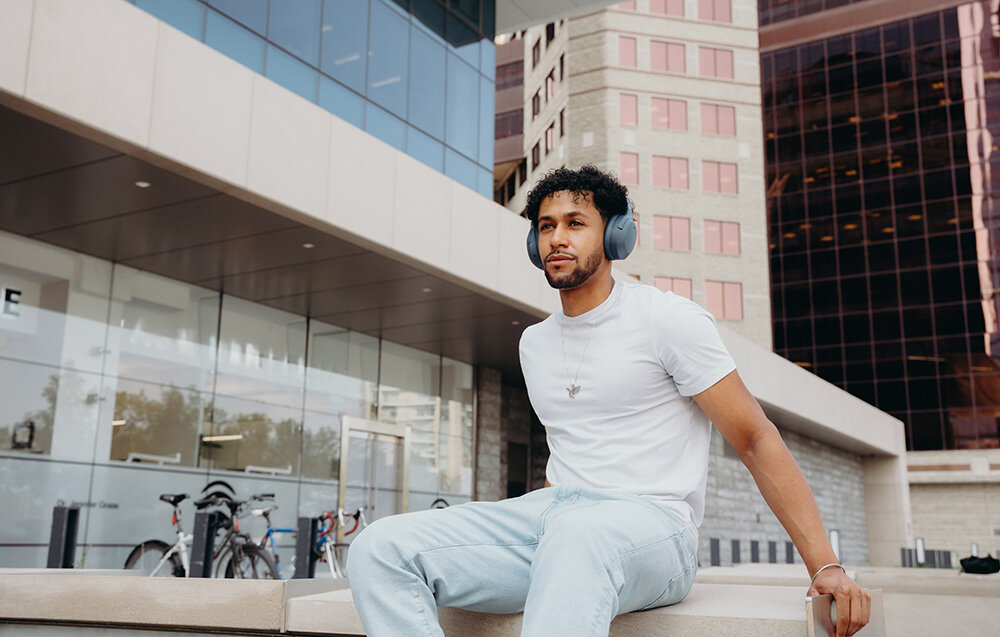 Edifier W820NB Plus V25 bateria 88h szybkie ładowanie 15min 15h ANC, osoba z założonymi słuchawkami nausznymi w plenerze