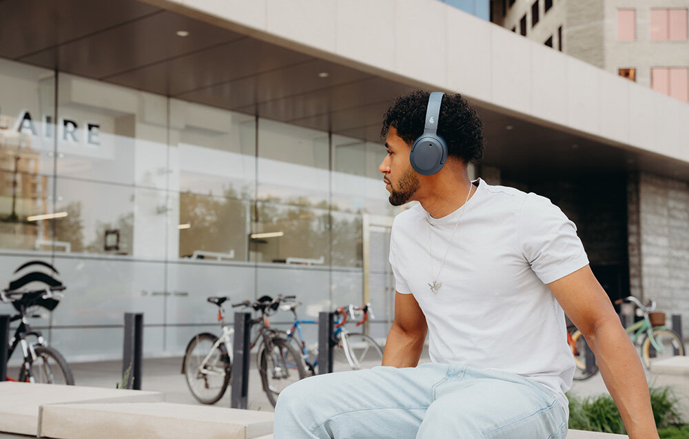 Edifier W820NB Plus V25 aplikacja ConneX Volume Guard przyciski diody sterowanie EQ, osoba z założonymi słuchawkami nausznymi w plenerze