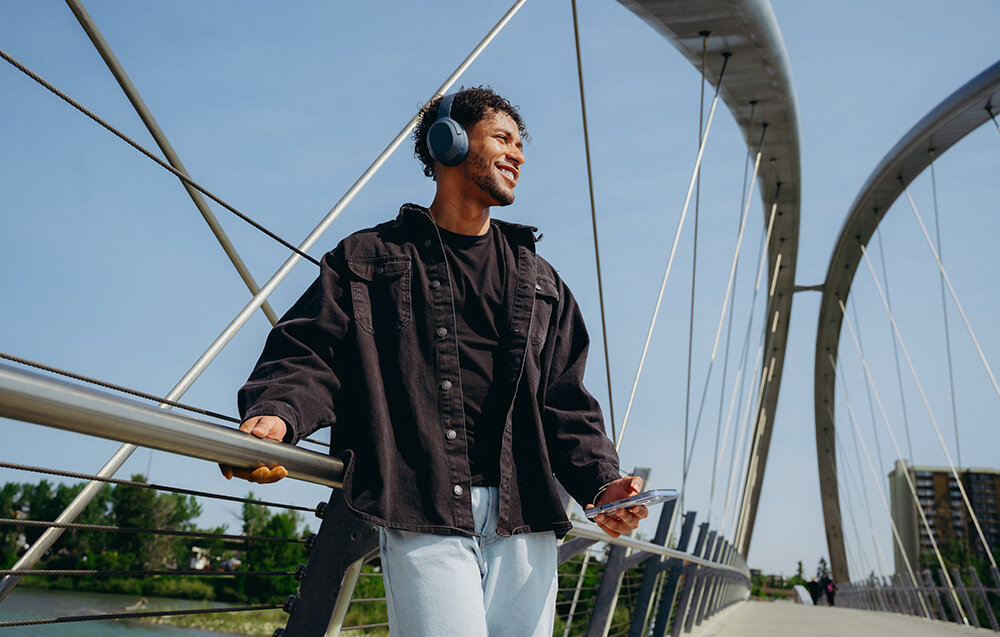 Edifier W820NB Plus V25 komfortowe lekkie słuchawki nauszne regulowany pałąk elegancki design, osoba z założonymi słuchawkami nausznymi w plenerze