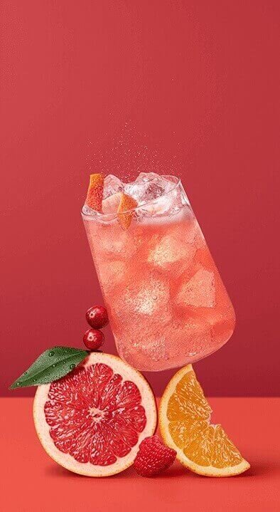 Wlewanie pomarańczowego napoju z dzbanka do butelki SodaStream na blacie