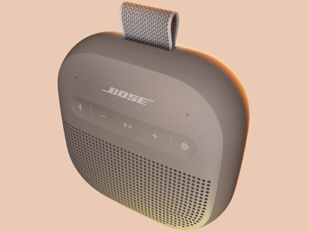 Głośnik mobilny BOSE SoundLink Micro 2nd Gen kompaktowy głośnik Bluetooth o potężnym brzmieniu i przenośnej konstrukcji, głośnik po skosie na beżowym tle