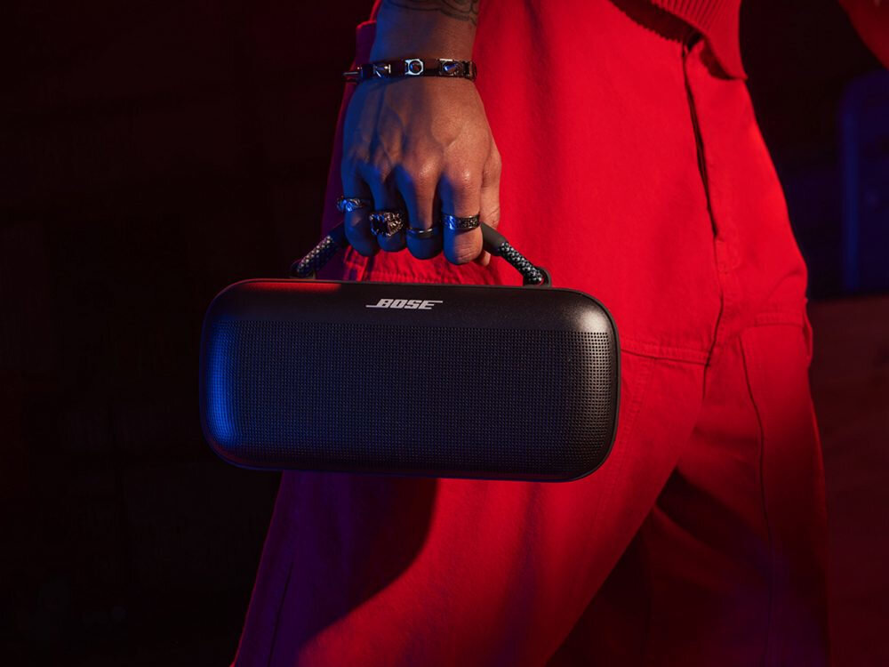 Głośnik BOSE SoundLink Max pełny dźwięk stereo dla imprez, osoba trzymająca głosnik za uchwyt