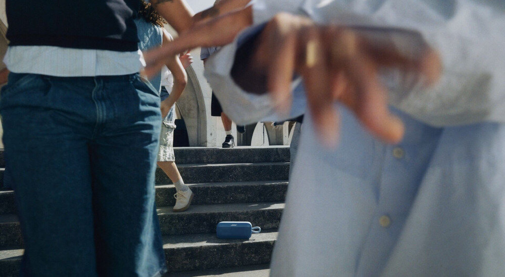 Głośnik mobilny BOSE SoundLink Plus ładowanie USB-C powerbank do telefonu, osoby chodzące po schodach, głośnik stojący na schodach