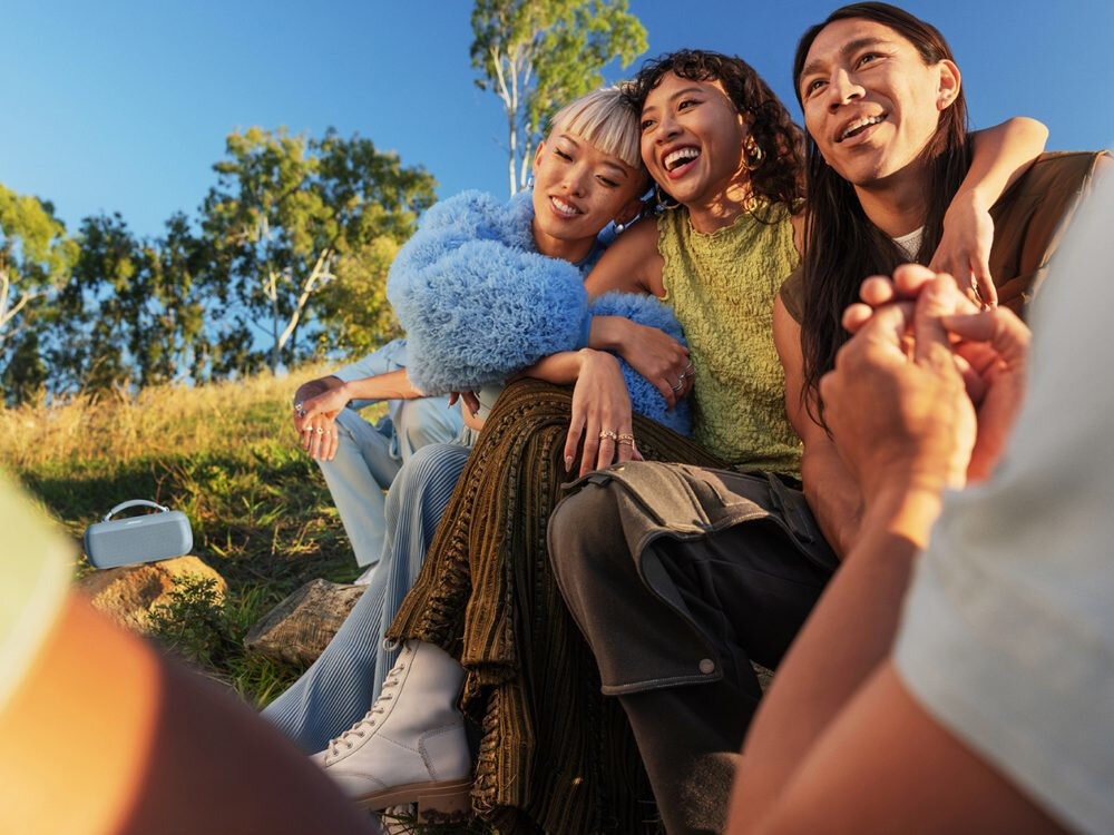 BOSE SoundLink Max 20 godzin pracy nieprzerwana muzyka, osoby siedzące na kamieniach, głośnik stojący na kamieniach