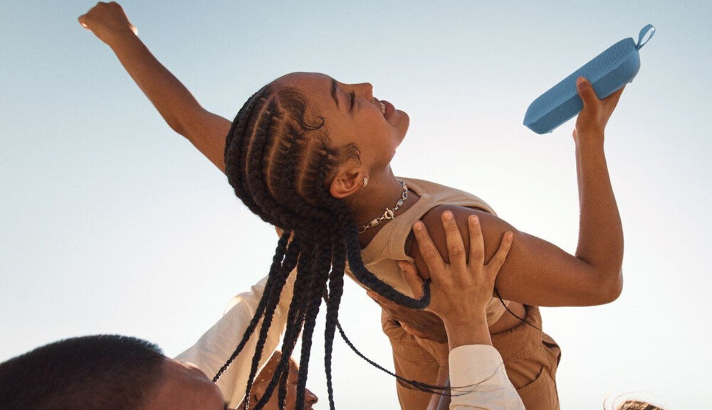 Głośnik mobilny BOSE SoundLink Flex 2 gen technologia PositionIQ automatyczne dopasowanie dźwięku do położenia, osoba trzymająca głośnik w reku