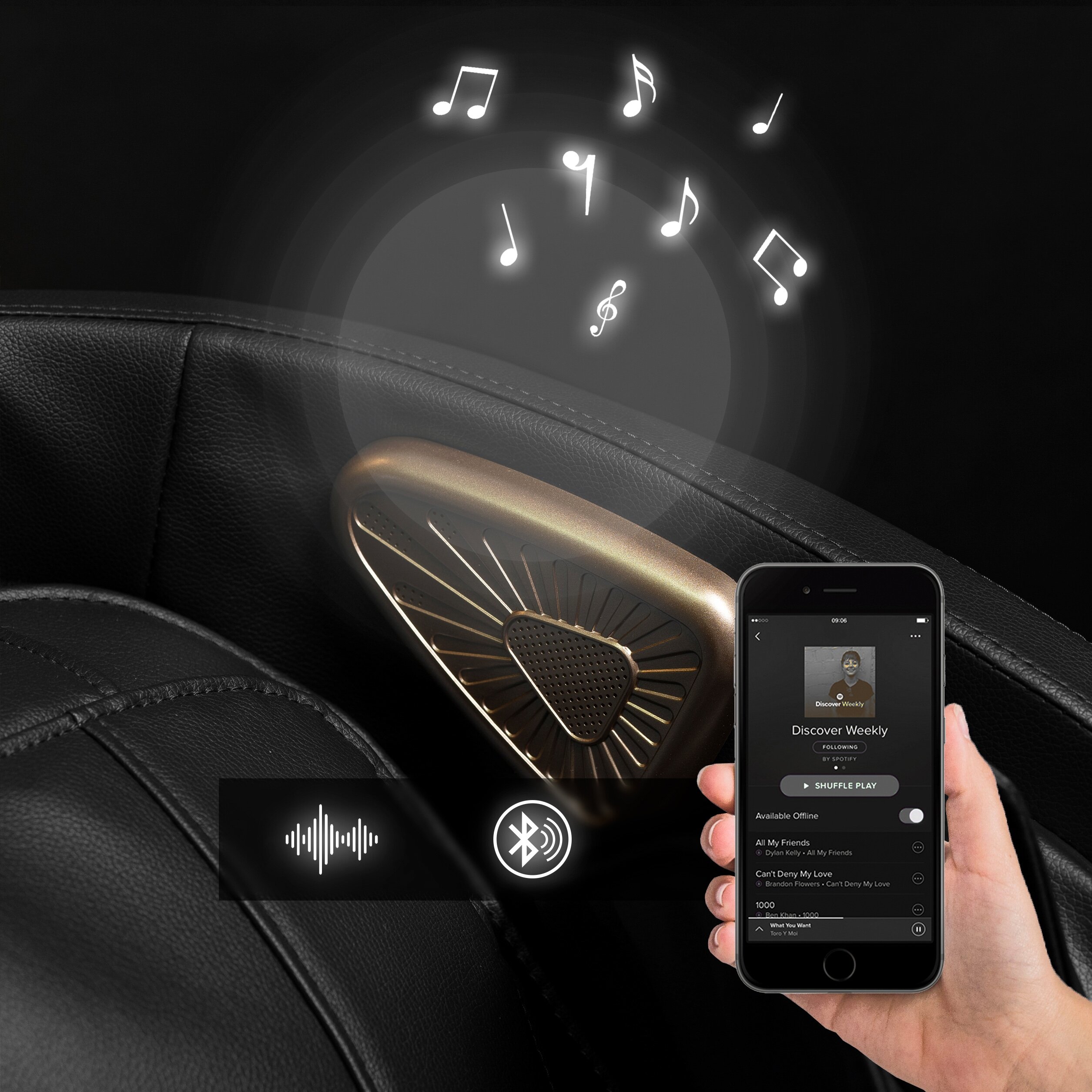Czarny fotel masujący z wbudowanym głośnikiem, z którego wydobywają się symbole nut. Obok widoczny jest smartfon z aplikacją muzyczną i ikonami Bluetooth oraz dźwięku.