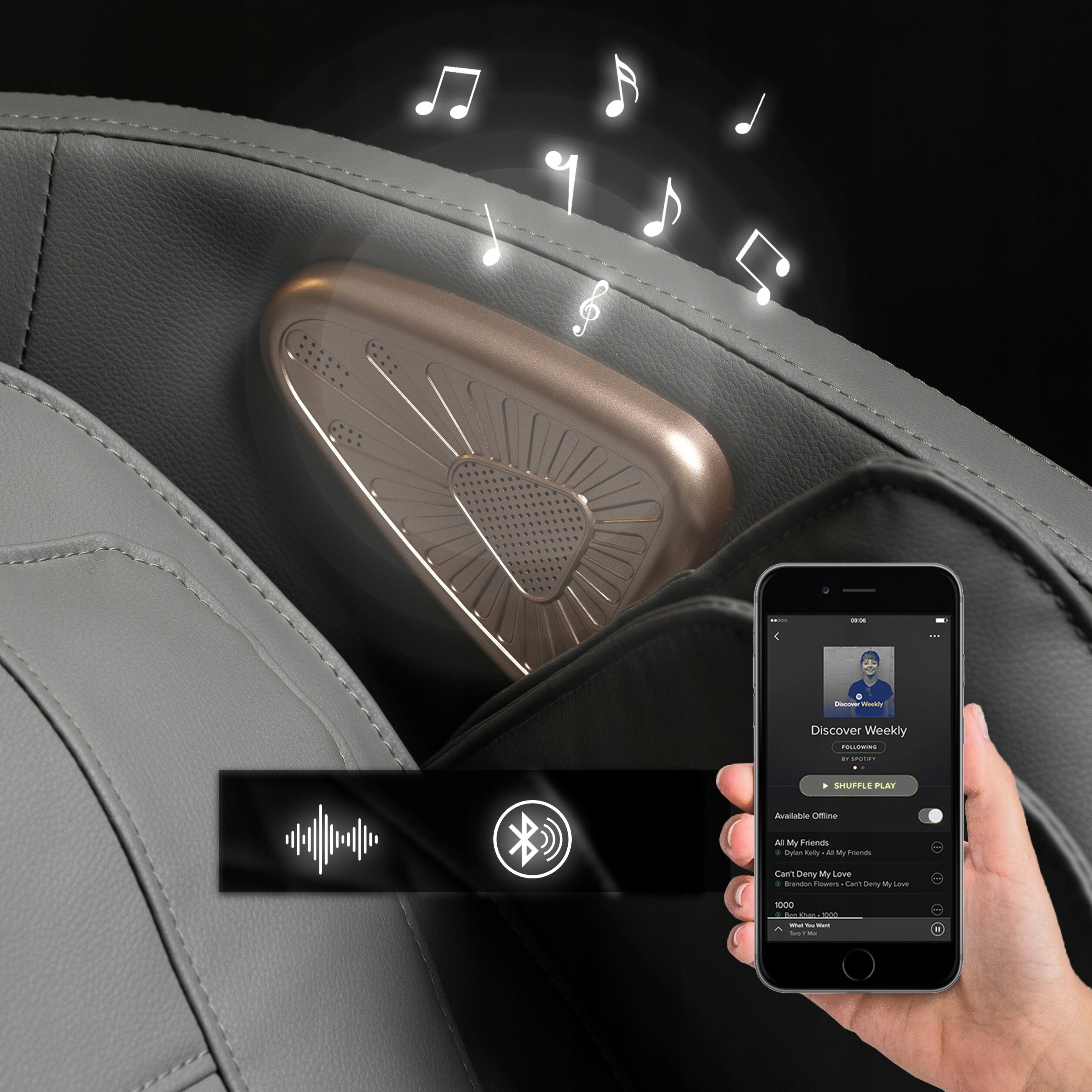 Szary fotel masujący z wbudowanym głośnikiem, z którego wydobywają się nuty muzyczne. Obok widoczny jest smartfon z aplikacją muzyczną i ikonami Bluetooth oraz dźwięku.