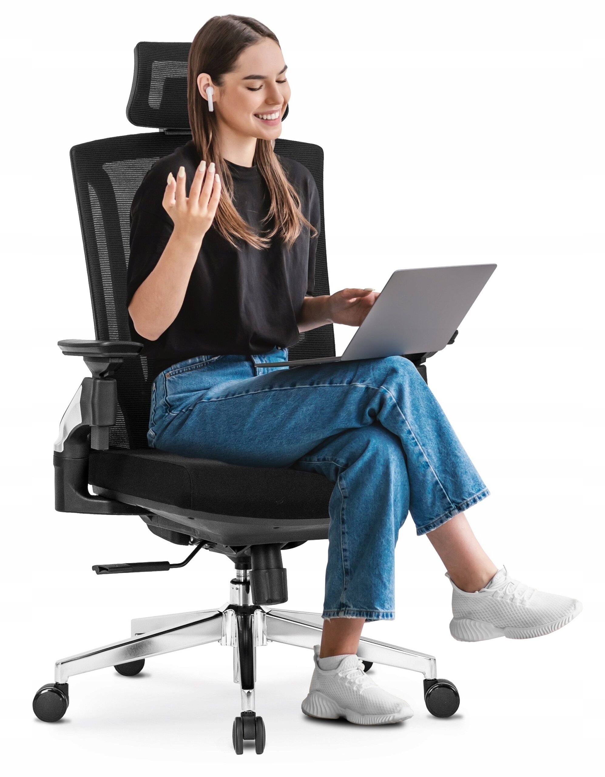 Osoba siedzi na czarnym, ergonomicznym krześle obrotowym, trzymając laptopa na kolanach. Krzesło ma metalową podstawę z kółkami i regulowane podłokietniki.