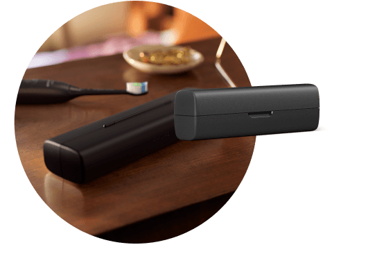 Na blacie leży etui, a za nim szczoteczka. Obok znajduje się etui podróżne.